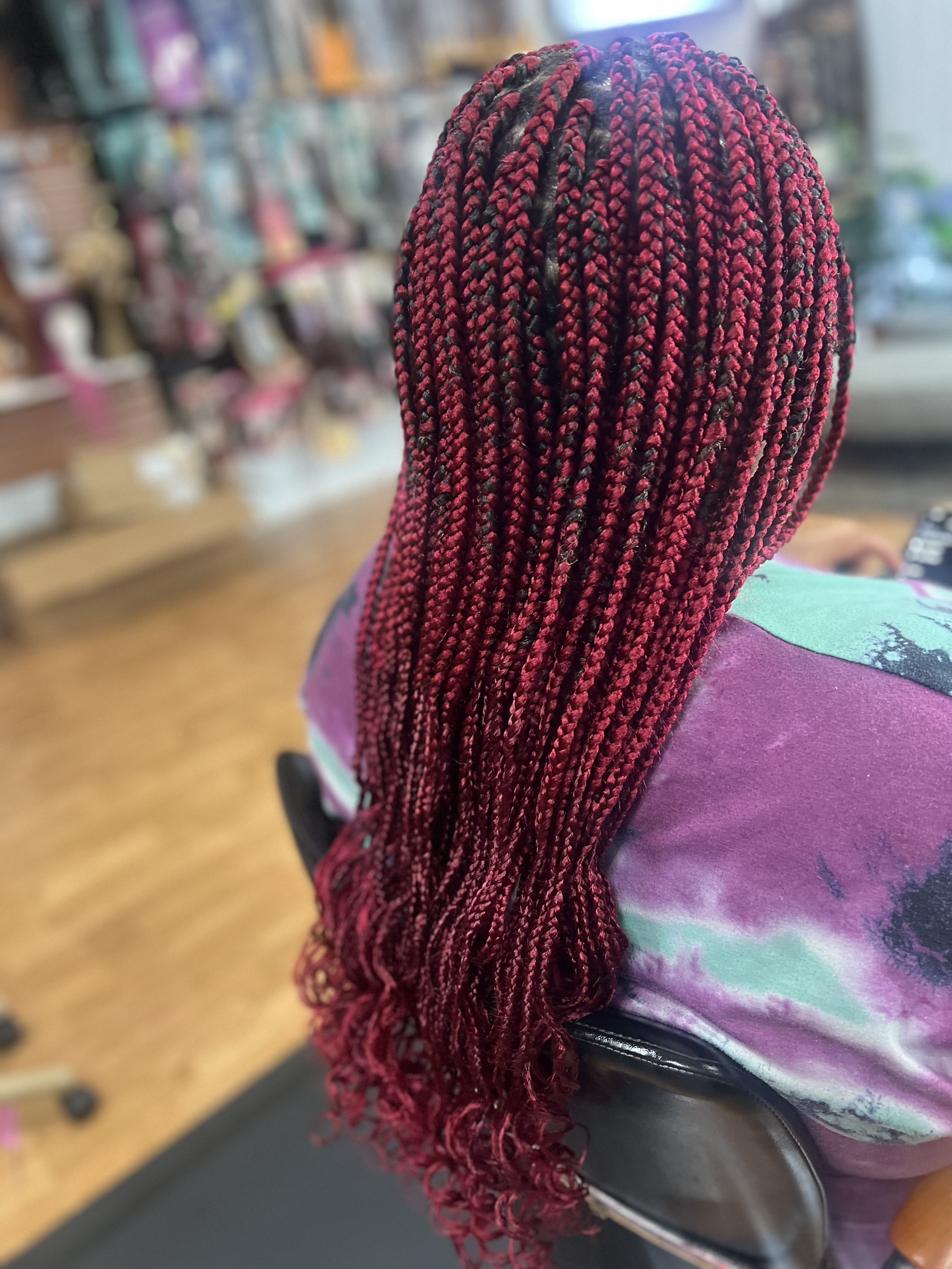 Beautiful red knotless braids with curly ends by MJADE Beauty in Chandler AZ